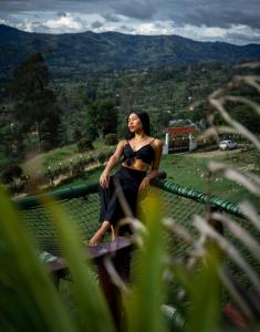 a woman in a bikini sitting on a bridge at Amore Mio Glamping in Jenesano