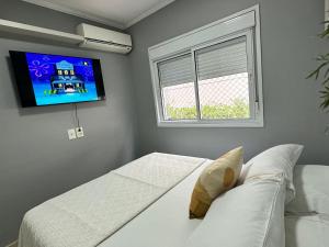una camera da letto con due letti e una TV a parete di Maravilhoso AP inteiro em frente Hospital Albert Einstein e Estádio Morumbis a San Paolo Altre 48 foto