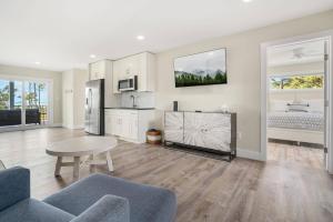 a living room with a table and a kitchen at Wildcat Haven - Waterfront & phenomenal views! in Deep Hole