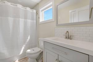 a bathroom with a toilet and a sink and a mirror at Wildcat Haven - Waterfront & phenomenal views! in Deep Hole +80 photos