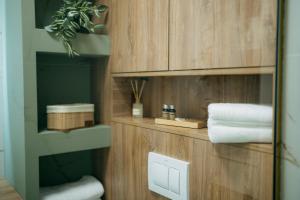 Un baño con paredes de madera y un estante con toallas. en SXB Skyline Luxury Suite, en Brasov