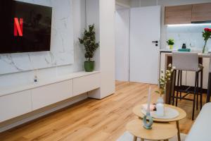 a living room with a tv and a table at SXB Skyline Luxury Suite in Braşov