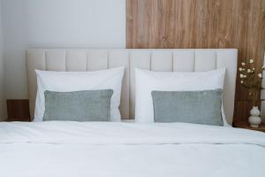 a bed with white sheets and pillows in a bedroom at SXB Skyline Luxury Suite in Braşov