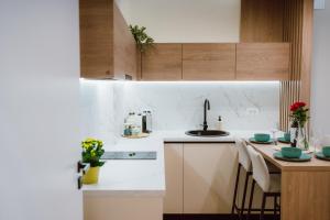 a kitchen with white counters and a table with chairs at SXB Skyline Luxury Suite in Braşov