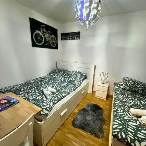 a bedroom with two twin beds and a table and a rug at München Haus-Centrum-Messe-Oktoberfest -7-24 CHECKIN in Munich
