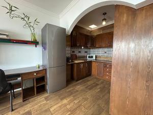 Una cocina con gabinetes de madera y un refrigerador de acero inoxidable. en Los Marineros, en Gran Tarajal