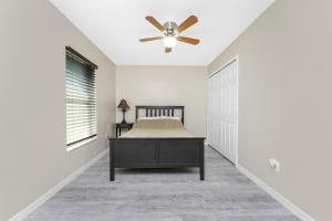 Un dormitorio con una cama y un ventilador de techo. en The Spacious Florida Oasis, en Arcadia