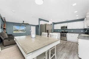 Una cocina con gabinetes blancos y una mesa grande. en The Spacious Florida Oasis, en Arcadia