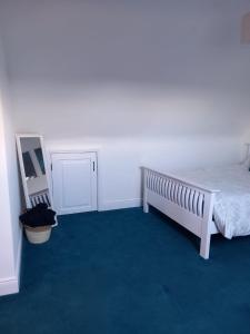 a bedroom with a bed and a blue carpet at Cosy East Clare Apartment in Coolcoosaun