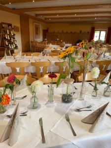 a large room with tables with flowers in vases at Gasthof Janser in Altenstadt
