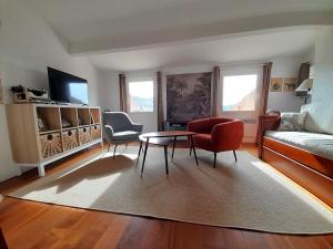 a living room with a couch and a table and chairs at L'atelier au coeur du village in Roussillon