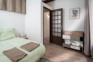 a bedroom with a large bed and a door at Charmant Appartement au Cœur du Village de Bedoin in Bédoin