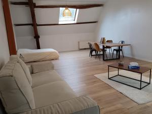 a living room with a couch and a table at Le Cocon Tannaysien in Tannay