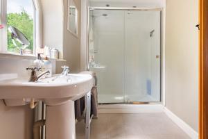 a bathroom with a sink and a shower at Grooms Cottage in Weedon Bec +36 photos
