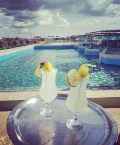 two cocktails sitting on a table in front of a swimming pool at Ecovila Sertão in Petrolândia +14 photos