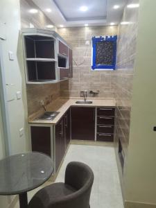 a small kitchen with a sink and a table at شقق مفروشه قارا in Qārā