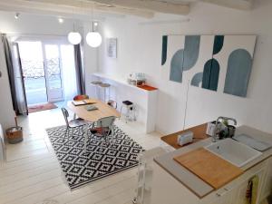 a kitchen with a table and a dining room at L'atelier au coeur du village in Roussillon