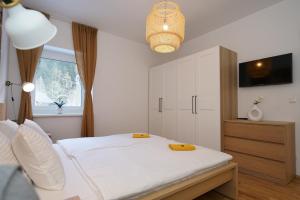a bedroom with a white bed and a window at SCHUSTER's ALPENPANORAMA in Seewiesen