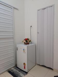 a white refrigerator with a plant on top of it at Linda kitnet mobiliada 05 in Salvador