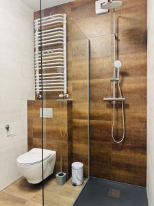 a bathroom with a toilet and a glass shower at Apartamenty Baltic Sea Wiedeńska 5 in Kołobrzeg