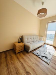 a living room with a white couch and a window at Apartamenty Baltic Sea Wiedeńska 5 in Kołobrzeg +9 photos