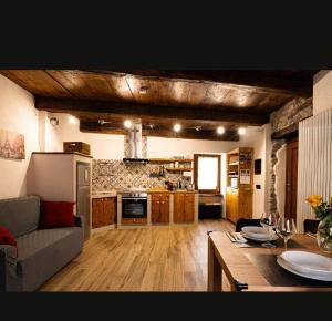 a kitchen and living room with a couch and a table at Il fiore di pietra in Cuzzago