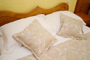a white bed with two pillows on it at Hotel Marija in Kotor