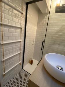 a bathroom with a white sink and a shower at Élégant duplex neuf à 30 m de l'Océan avec parking in Lacanau +1 photo