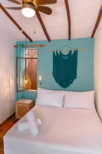 a bedroom with a white bed with a blue wall at Traveler Hostel in San Gil +75 photos
