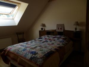 una camera da letto con un letto con una trapunta sopra di Au Doubs Moulin a Bians-les-Usiers