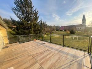 una terrazza con recinto, albero e chiesa di Au Doubs Moulin a Bians-les-Usiers Altre 7 foto