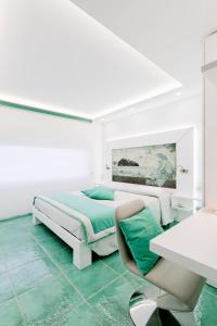 サレルノにあるラ マデグラ シースイートの白いベッドルーム(ベッド1台、デスク付)