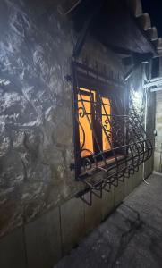 a window on the side of a stone wall at night at Clara Sweet Dreams in Isola Sacra