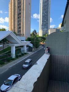 two cars parked on the side of a street with buildings at pousada vista in Salvador