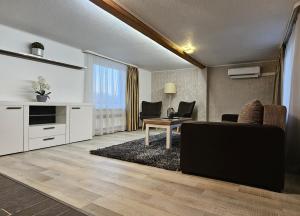 a living room with a couch and a table at Baltā māja 56m2 in Tukums