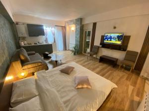 a living room with a bed and a living room with a tv at Cosmo Apartament in Eforie Nord