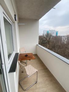 a balcony with a chair and a table and a window at Cosmo Apartament in Eforie Nord