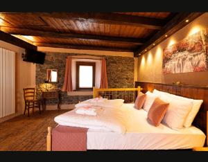 a bedroom with a large white bed in a room at Il fiore di pietra in Cuzzago