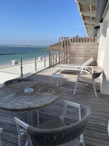 a wooden deck with a table and chairs on the beach at Les Sables Blancs in Concarneau