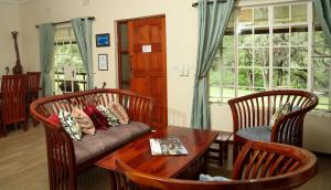 a living room with a couch and a table at Woodlands Stop Over and Lodge in Francistown +121 photos
