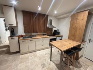 a kitchen with a wooden table and a counter top at Charmant appartement in Nancy