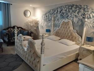 a bedroom with a white bed with a mural at Shantel in Haifa