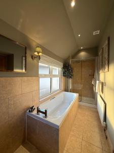 a large bathroom with a tub and a shower at The Red Lion Inn Alnmouth in Alnmouth +37 photos