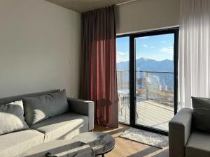 a living room with a couch and a large window at High Gudauri - Ski in ski out - loft in Gudauri