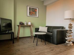 ein Wohnzimmer mit einer Couch und einem Tisch in der Unterkunft "Unnen" in der Alten Schule Greetsiel in Krummhörn