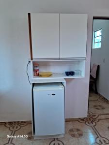 a white refrigerator in a kitchen with a cabinet at apartamento só pra vc e sua familia in Belém