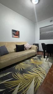 a living room with a couch and a rug at HOPE-always in Cape Town