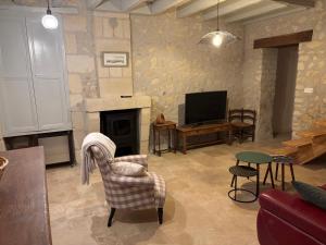 a living room with a fireplace and a tv at Gîte les Huttières in Cravant-les-Coteaux