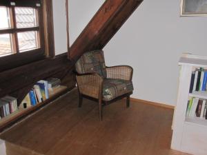 uma cadeira num quarto com uma estante de livros em Ferienhaus Fam. Fuhrer em Hohenaltheim