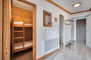 Una habitación con dos literas y un pasillo. en Appartement N° 46, en Les Menuires
